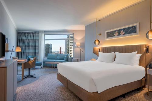 Habitación con cama extragrande y sofá cama del hotel Hilton Diagonal Mar Barcelona. Foto 4