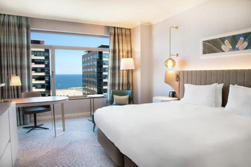 Habitación con cama extragrande y vistas a la piscina del hotel Hilton Diagonal Mar Barcelona. Foto 1