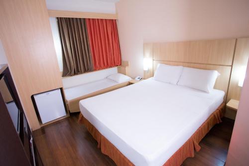 Habitación Standard con una cama doble y una cama supletoria para niño del hotel Ibis Feira De Santana. Foto 7