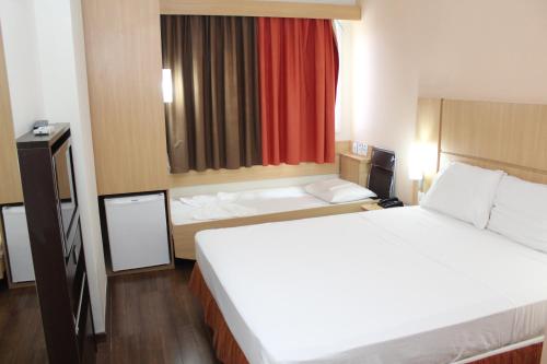 Habitación Standard con una cama doble y una cama supletoria para niño del hotel Ibis Feira De Santana. Foto 11