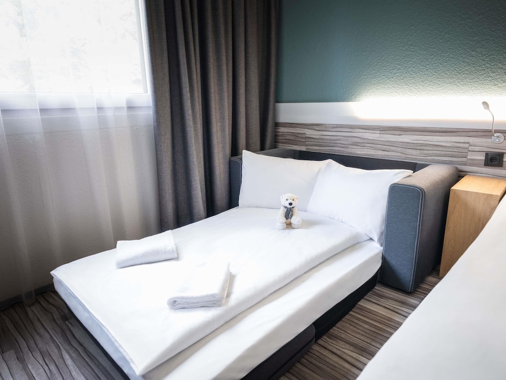 Habitación familiar con 1 cama king size y sofá - cama del hotel Ibis Styles Linz. Foto 7