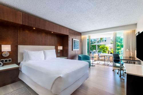 Habitación con cama grande, cama doble supletoria, balcón y vistas al jardín del hotel Doubletree By Hilton San Juan. Foto 2