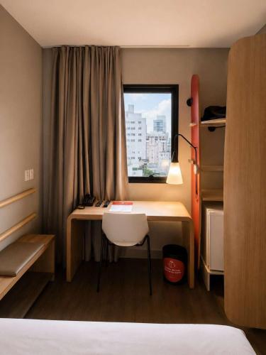 Habitación con 1 cama doble, 1 cama individual y vistas al mar del hotel Ibis Santos Gonzaga Praia. Foto 1