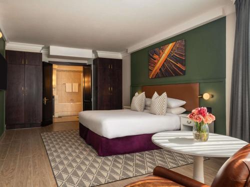 Suite de 1 dormitorio con cama extragrande y vistas al jardín del hotel Mövenpick Hotel Windhoek. Foto 1