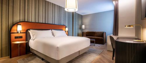 Habitación con cama extragrande y sofá cama del hotel Doubletree By Hilton Brussels City