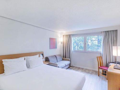 Habitación Doble Estándar con sofá cama y vistas a la piscina del hotel Novotel Setubal
