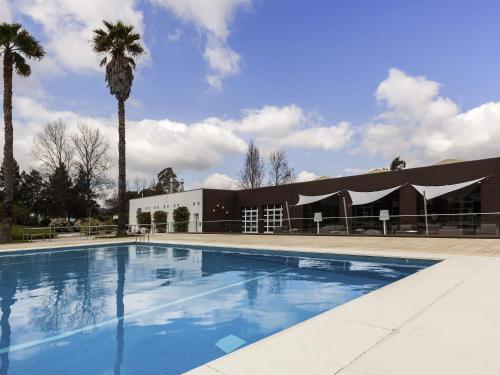 Habitación Doble Estándar con sofá cama y vistas a la piscina del hotel Novotel Setubal. Foto 6