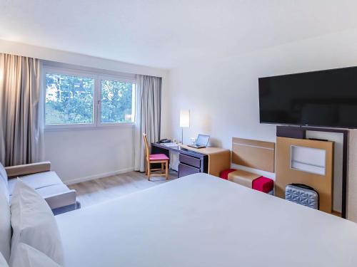 Habitación Doble Estándar con sofá cama y vistas a la piscina del hotel Novotel Setubal. Foto 9