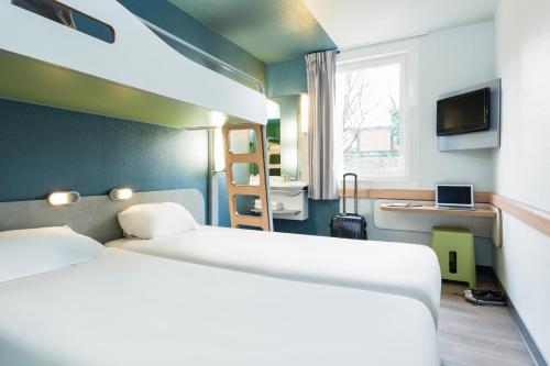 Habitación Triple con cama doble y litera del hotel Ibis Budget Paris Porte De Montmartre. Foto 4