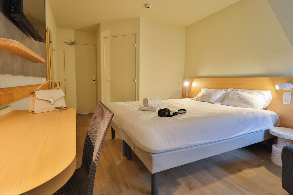 Habitación familiar con una cama grande y un sofá cama del hotel Ibis Budget Aix Les Bains Nord. Foto 1