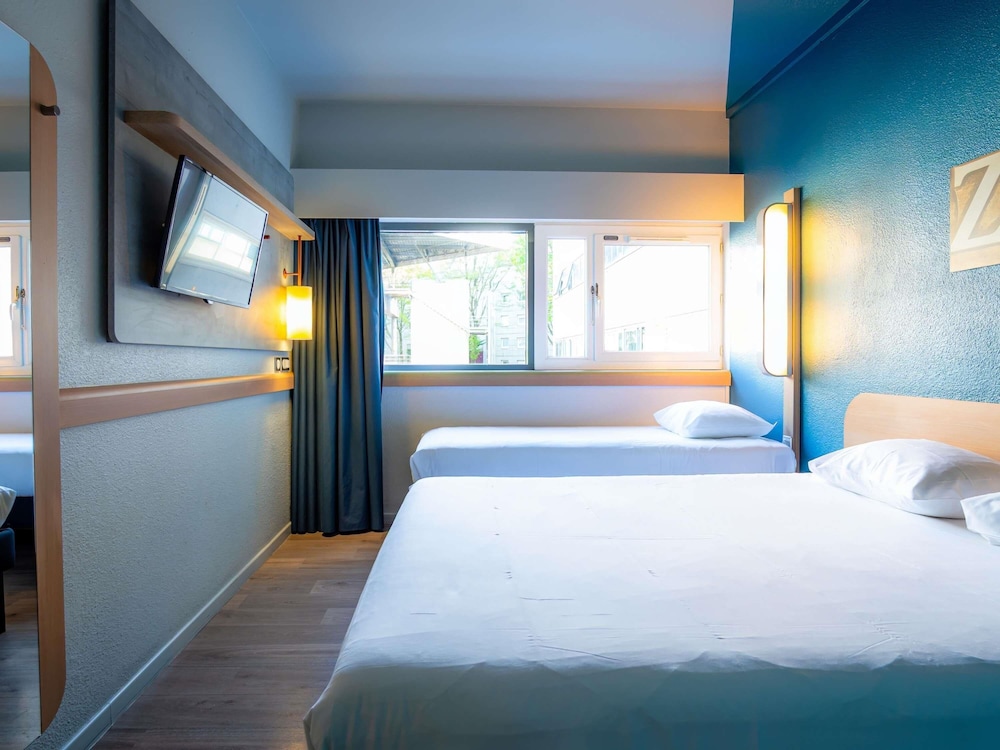 TRIPLE - Habitación con una cama grande y una cama litera del hotel Ibis Budget Paris Porte De Pantin. Foto 1