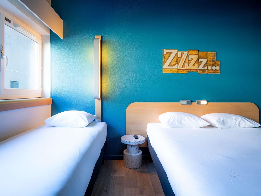 TRIPLE - Habitación con una cama grande y una cama litera del hotel Ibis Budget Paris Porte De Pantin. Foto 9