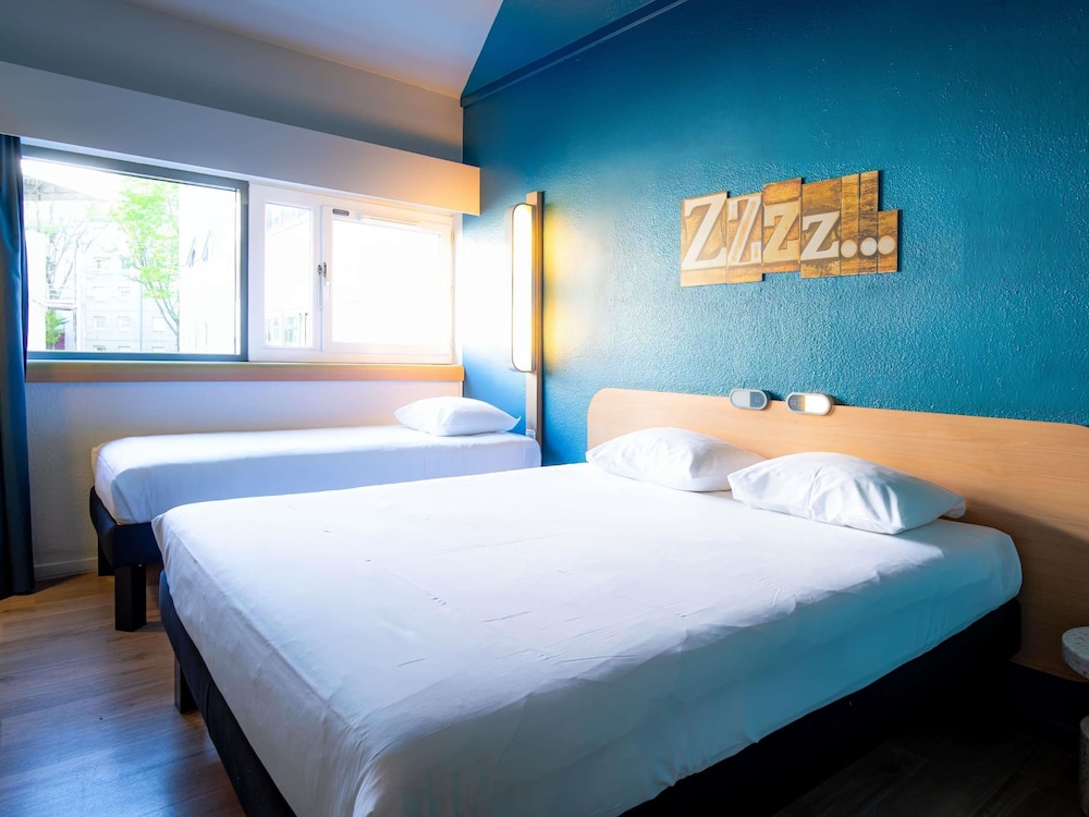 TRIPLE - Habitación con una cama grande y una cama litera del hotel Ibis Budget Paris Porte De Pantin. Foto 12