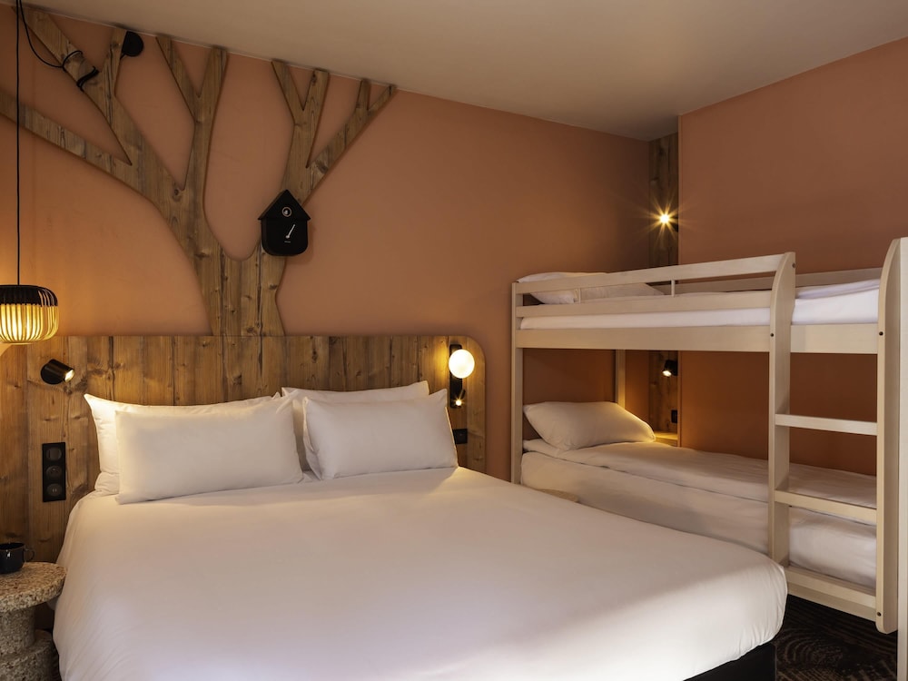 Habitación con cama doble, literas y chaise longue individual del hotel Ibis Styles Les Houches Chamonix