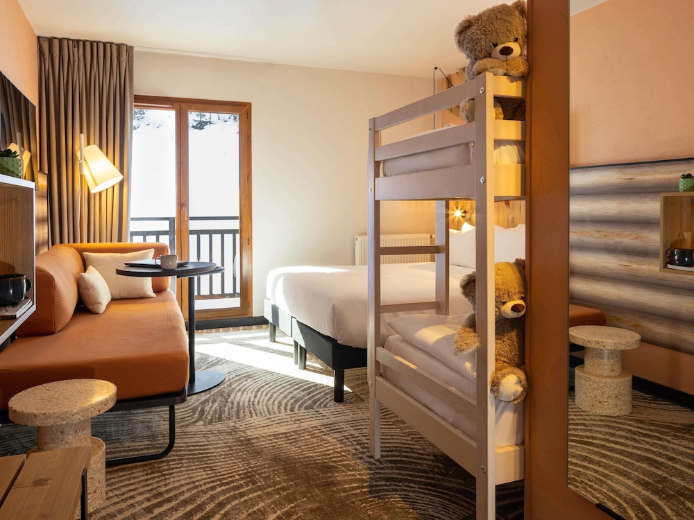 Habitación con cama doble, literas y chaise longue individual del hotel Ibis Styles Les Houches Chamonix. Foto 6