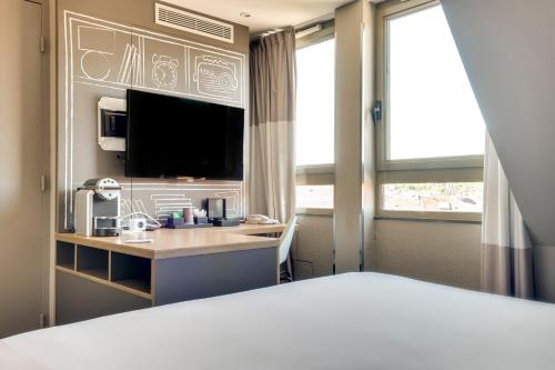 Habitación Confort con cama doble y sofá cama individual del hotel Ibis Paris Rueil Malmaison. Foto 11