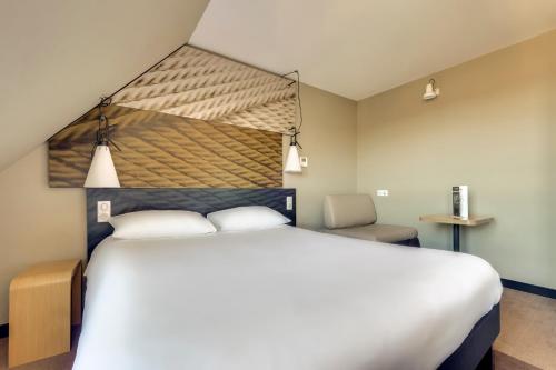 Habitación Confort con cama doble y sofá cama individual del hotel Ibis Paris Rueil Malmaison. Foto 12