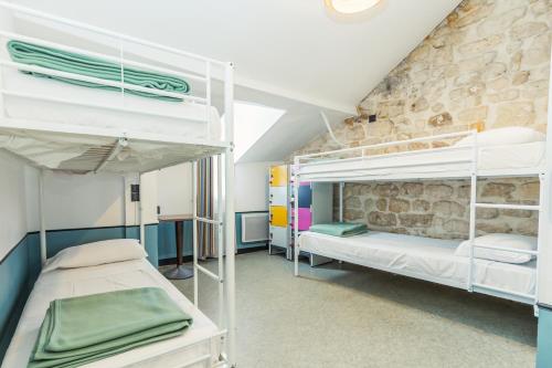 Cama en habitación compartida mixta con 6 camas y baño compartido del hotel Young And Happy Latin Quarter By Hiphophostels