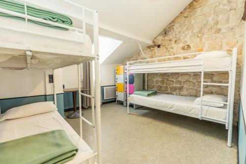 Cama en habitación compartida mixta con 6 camas y baño compartido del hotel Young And Happy Latin Quarter By Hiphophostels. Foto 3