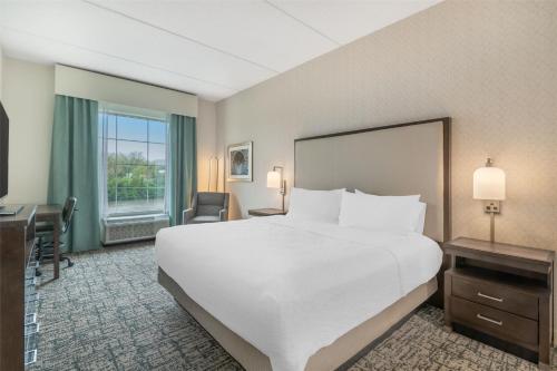 Suite de 1 dormitorio con cama extragrande, balcón y vistas del hotel Homewood Suites By Hilton Schenectady