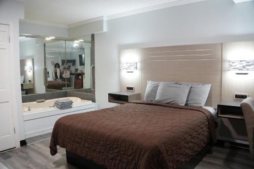 Habitación con cama grande y bañera de hidromasaje del hotel Relax Inn