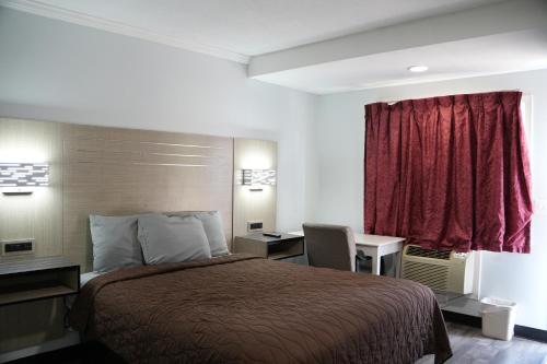Habitación con cama grande y bañera de hidromasaje del hotel Relax Inn. Foto 3