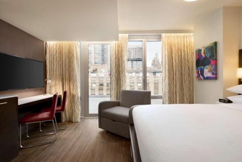 Habitación con balcón y vistas al Empire State Building - Cama extragrande del hotel Embassy Suites By Hilton New York Manhattan Times Square. Foto 1