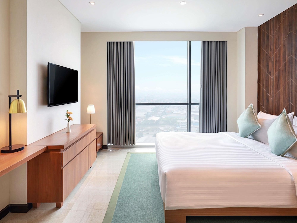 Suite Ejecutiva con 1 cama king size, 1 cama queen size y 2 camas individuales del hotel Novotel Samator Surabaya Timur. Foto 2