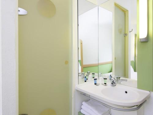 TRIPLE - Habitación con una cama grande y una cama litera del hotel Ibis Budget Lyon Gerland. Foto 6