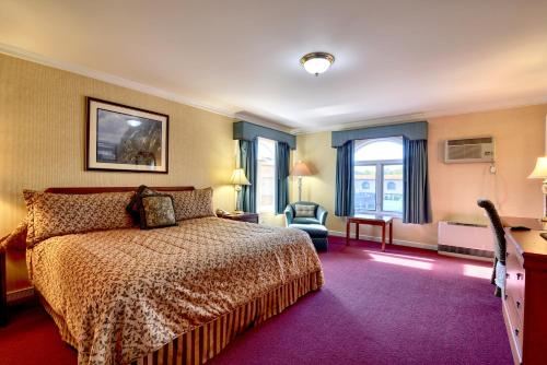 Habitación Deluxe con cama extragrande y oficina en el edificio principal del hotel Roosevelt Inn & Suites Saratoga Springs. Foto 3