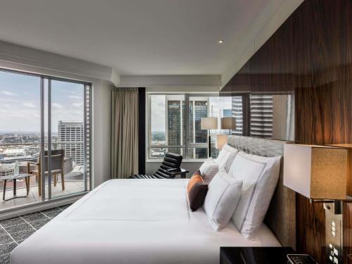 Habitación esquinera con cama extragrande y balcón del hotel Swissotel Sydney