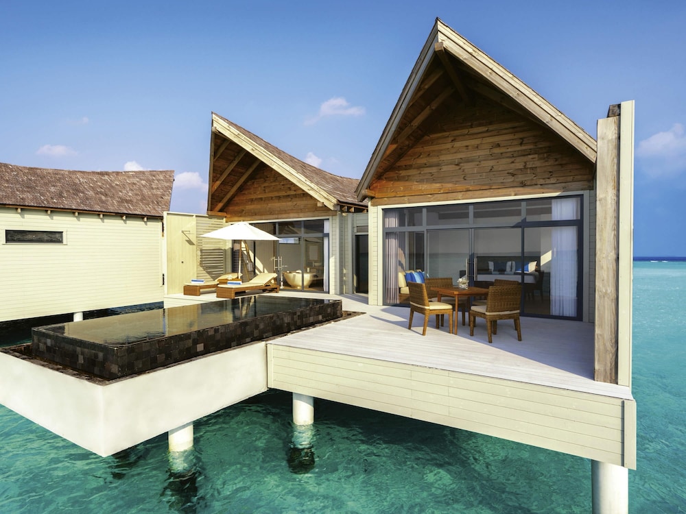 Villa sobre el agua con piscina al amanecer del hotel Kuredhivaru Resort and Spa Maldives