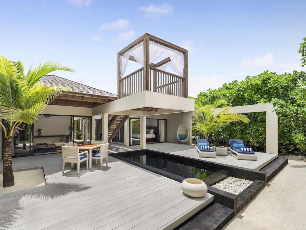 Villa en la playa con piscina al atardecer del hotel Kuredhivaru Resort and Spa Maldives