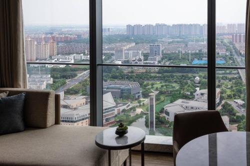 Habitación con 2 camas dobles y vistas al jardín del hotel Zhangjiagang Marriott. Foto 1