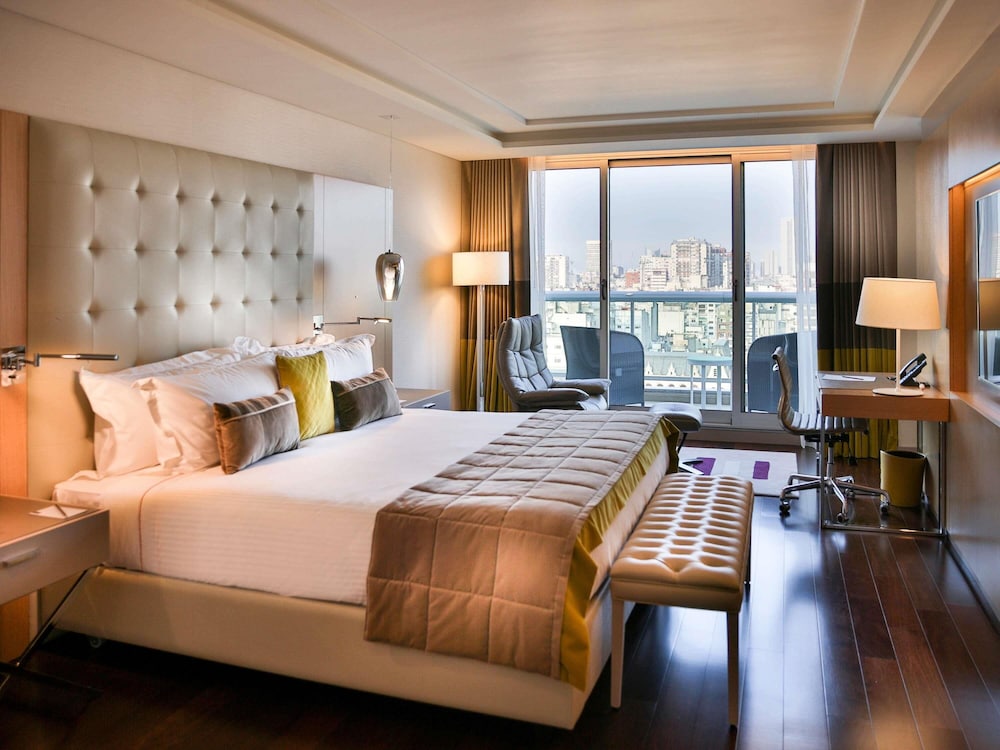 Suite Palladio Executive con una cama king size y balcón con vistas a la ciudad y el parque del hotel Palladio Buenos Aires MGallery