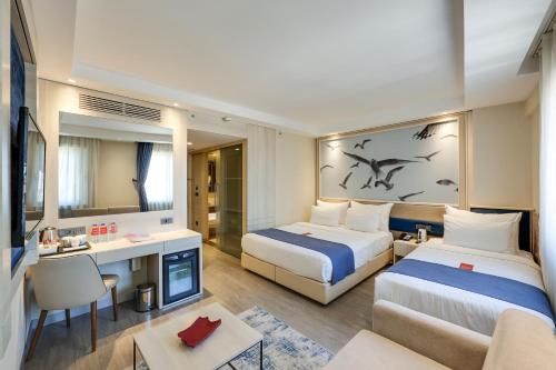Habitación Familiar, una cama doble, una cama individual y sofá cama del hotel Ramada By Wyndham Istanbul Old City. Foto 1