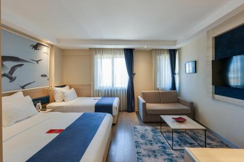 Habitación Familiar, una cama doble, una cama individual y sofá cama del hotel Ramada By Wyndham Istanbul Old City. Foto 3
