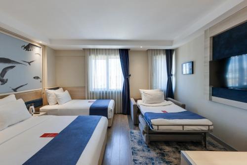 Habitación Familiar, una cama doble, una cama individual y sofá cama del hotel Ramada By Wyndham Istanbul Old City. Foto 4