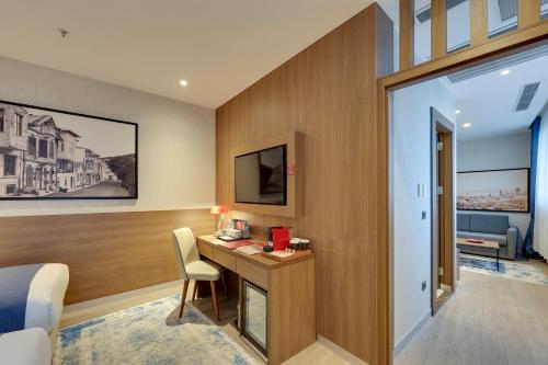 Habitación Executive, tres camas individuales y sofá cama del hotel Ramada By Wyndham Istanbul Old City. Foto 2