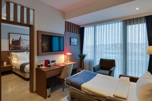 Suite con terraza, una cama doble y sofá cama del hotel Ramada By Wyndham Istanbul Old City. Foto 3
