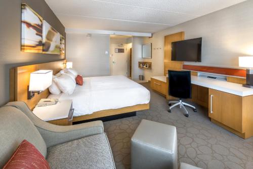 Habitación con cama extragrande y sofá cama del hotel Delta Hotels by Marriott Utica