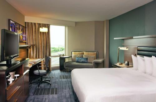 Habitación adaptada para personas de movilidad reducida con cama extragrande y bañera del hotel Hilton Newark Airport