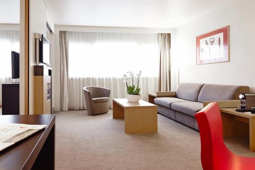 Suite con 1 cama doble y 1 sofá cama del hotel Novotel Paris Roissy CDG Convention. Foto 7