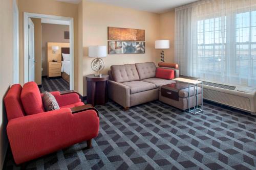 Suite de 1 dormitorio con cama grande y sofá cama del hotel TownePlace Suites by Marriott Republic Airport Long Island