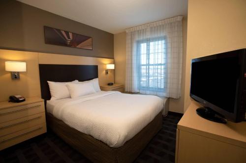 Suite de 1 dormitorio con cama grande y sofá cama del hotel TownePlace Suites by Marriott Republic Airport Long Island. Foto 1