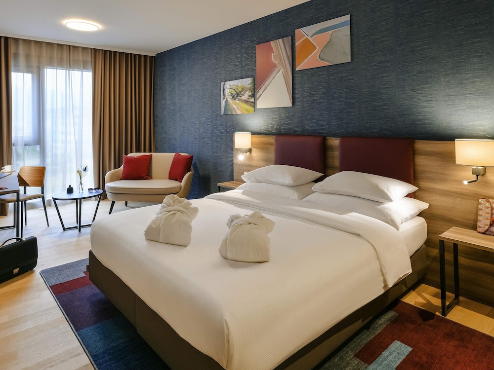 Habitaciones superiores situadas en las plantas superiores, modernas, elegantes y espaciosas del hotel Mercure Geneva Airport. Foto 1