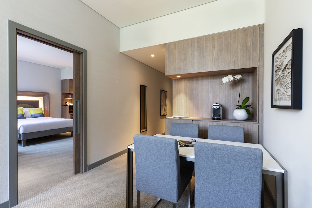 Suite Deluxe con 1 cama doble y 1 sofá cama grande del hotel Novotel Bur Dubai. Foto 1