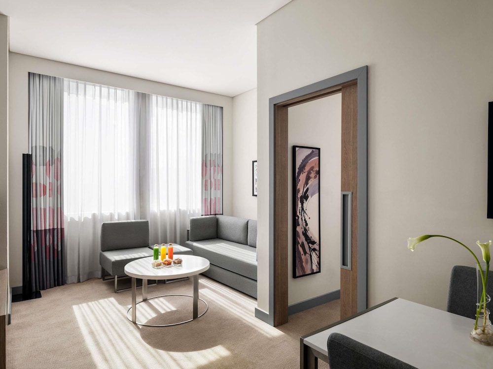 Suite Deluxe con 1 cama doble y 1 sofá cama grande del hotel Novotel Bur Dubai. Foto 4