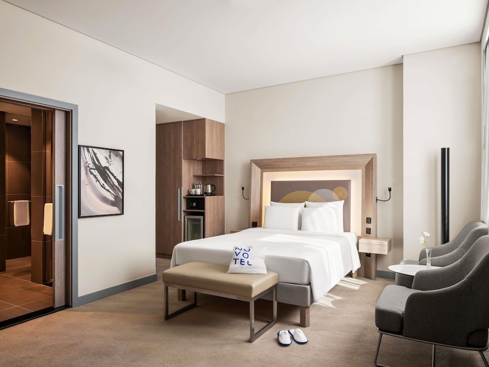 Suite Deluxe con 1 cama doble y 1 sofá cama grande del hotel Novotel Bur Dubai. Foto 5