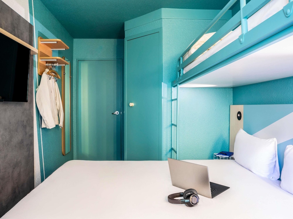 TRIPLE - Habitación con una cama grande y una litera del hotel ibis budget Marne la Vallee Chelles. Foto 3